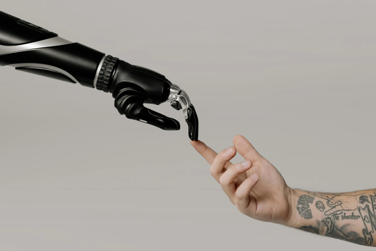 Menschliche Hand berührt Roboterhand. Credits cottonbro Studios.